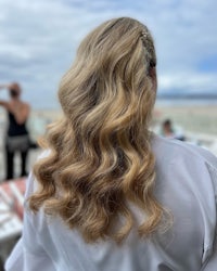 the back of a woman with long wavy hair at the beach