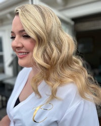 a woman in a white robe with long blonde hair